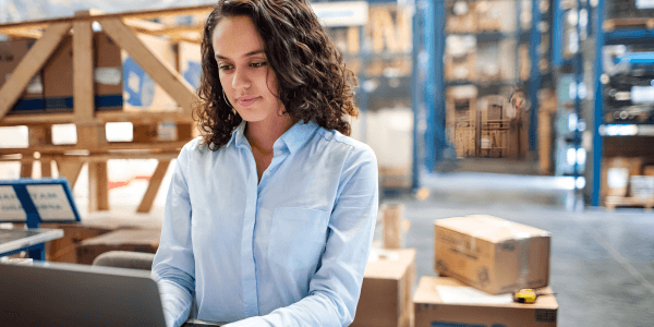 woman on laptop in warehouse